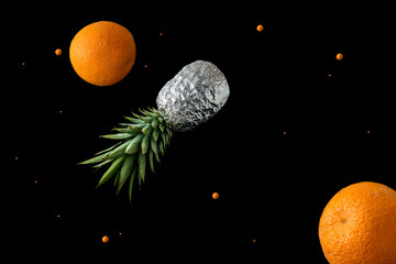 Summer food concept of cosmos with fresh oranges and pineapple fruits. Creative idea of space or...