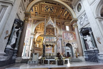 Obraz premium Perspective view of the apse of the Rome cathedral of San Giovanni in Laterano, with the papal altar, the inlaid ceiling and the vault with frescoes.