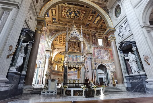 Perspective view of the apse of the Rome cathedral of San Giovanni in Laterano, with the papal altar, the inlaid ceiling and the vault with frescoes.