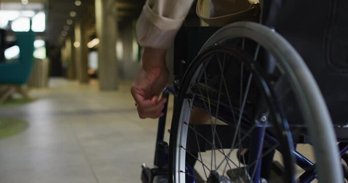 Disabled african american businessman in wheelchair in office corridor