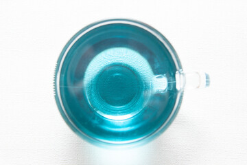 Anchan blue tea, herbal drink in glass cup from top view

