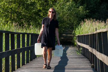 Ekero, Sweden A woman carries jugs of potable water on a dock.