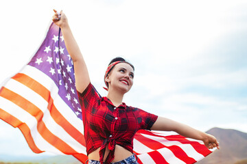 A young happy girl runs carelessly and jumps with open arms across the field at sunset. Holds the...