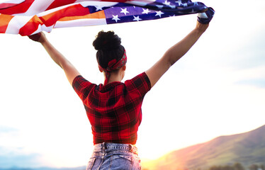 A young happy girl runs carelessly and jumps with open arms across the field at sunset. Holds the...