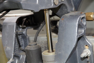 Motor boat outboard motor lower unit power trim and tilt cylinder with a chrome rod and hydraulic pump on transom bracket clamp