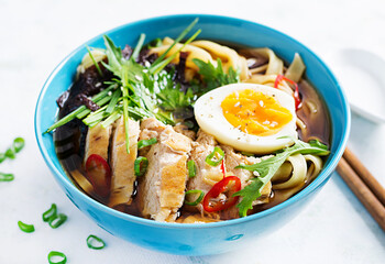 Miso soup. Japanese ramen soup with chicken, egg, nori and nipposinica on light background.