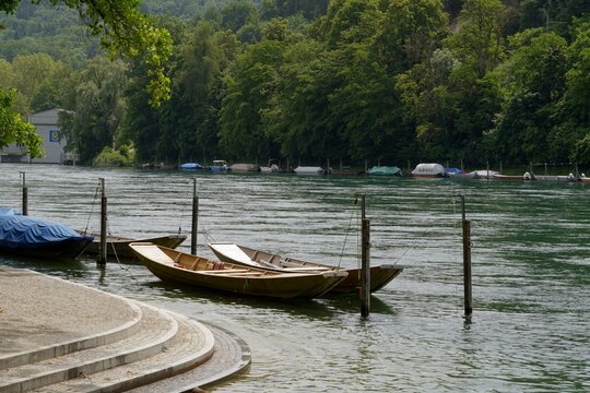 Wooden boats moored at promenade along Rhine river in Schaffhausen, Switzerland. They are called weidling boot in German language and they are traditional Swiss boats. River bank is regulated.