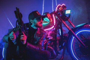 Naklejka na ściany i meble A special force agent with a rifle is hiding behind a futuristic motorbike and shooting. Cyberpunk concept.