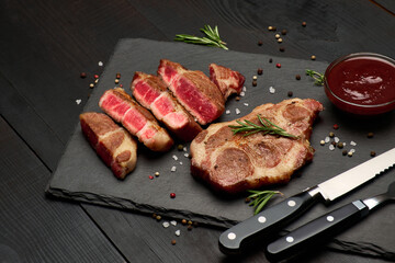 Grilled sliced roated beef steaks on stone serving cutting board