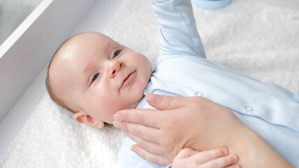 Mother's hand gently touching her baby face. Concept of baby care, parenting and family happiness.