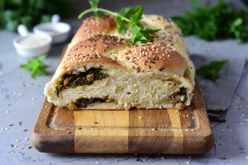 Vegetarian lunch: a hearty yeast pie with vegetable filling on a gray background.