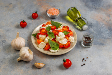 Delicious Italian Caprese salad with sliced red and orange cherry tomatoes.