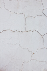Close up of textured cracked vertical white old wall background. Copy space option