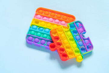 Silicone toys antistress pop it on blue background. New trend fidget for kids