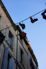 Chaussures colorées accrochées dans une ruelle du centre historique de Montpellier (Occitanie,...