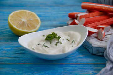 sauce crab sticks, parsley on a wooden background
