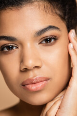 close up of pretty african american woman isolated on beige