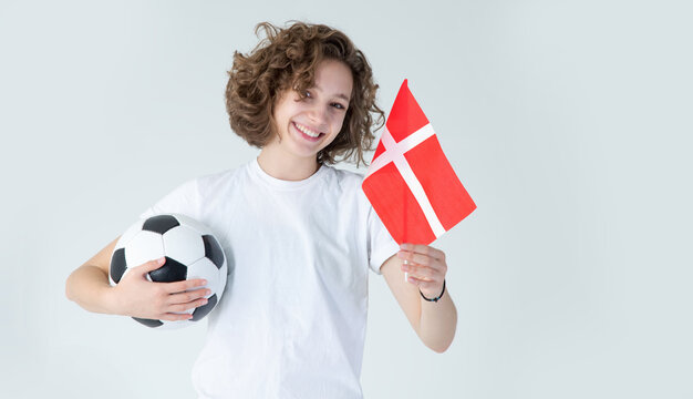 Beautiful young girl with a soccer ball and the flag of Denmark.