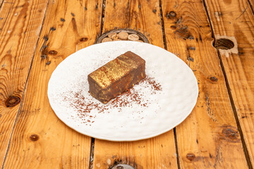 Chocolate and coffee ingot with golden coating and cocoa powder