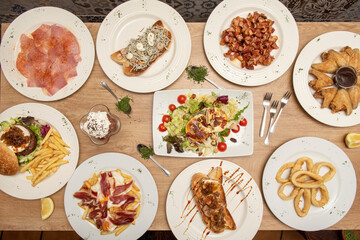 Ducks of typical gastronomy in Spanish tapas bars. Various toasts, cooked Galician pork, grilled ear, broken eggs with ham, battered squid