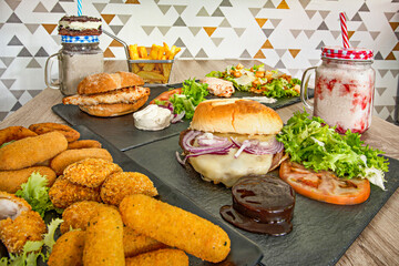 composition of chicken dishes, fast food, croquettes and battered hors d'oeuvres and fruit smoothies