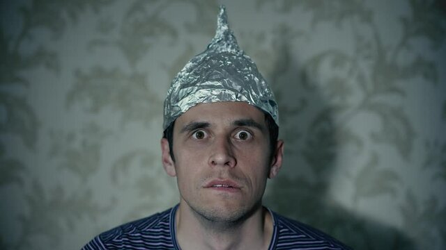 Man in a tin foil hat watching tv