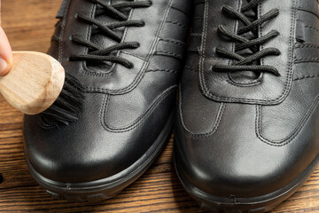 cleaning, polishing, restoration black leather boots with brush and footwear care product, shoe...
