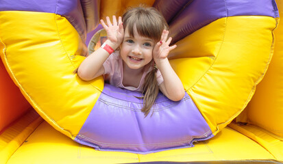 girl on an inflatable trampoline - obrazy, fototapety, plakaty