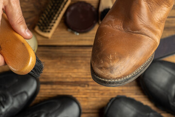 cleaning, polishing, restoration brown leather boots with brush and footwear care product, shoe...