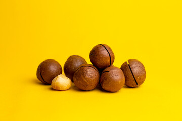 delicious and high-calorie macadamia nut on a yellow background