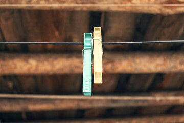 Ancient tools of old Latvia wooden fishing hutch - two yellow laundry pins on blue rope.