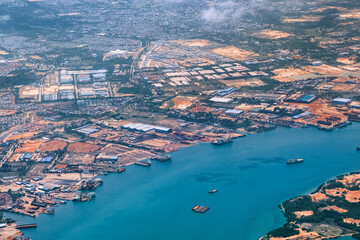 Aerial view of coastal construction or port areas in Strait of Malacca, on airplane route to Malaysia or Singapore. Airplane shot