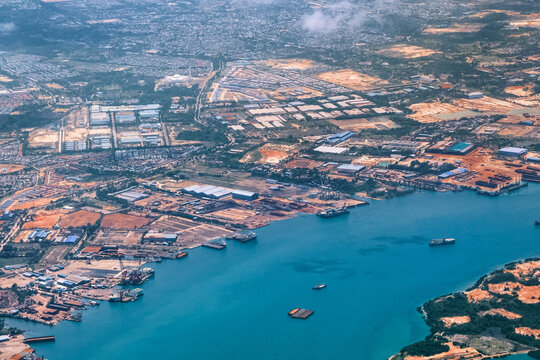 Aerial view of coastal construction or port areas in Strait of Malacca, on airplane route to Malaysia or Singapore. Airplane shot