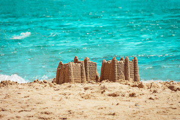 Sand castle with towers on the beach with view on the sea. Holiday concept with sand castle, Travel concept.