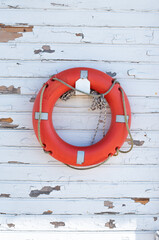 life buoy hanging on white wooden wall