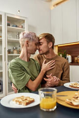 Homosexual young male lovers hugging at kitchen table