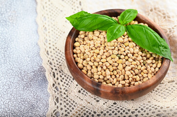 Fototapeta premium Soybeans in wooden bowl on light background