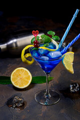 Blue lagoon cocktail with blue curacao liqueur, vodka, lemon juice and soda. Blue cocktail in martini glasses on black background
