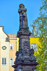 Obraz premium Fragment of a monument to a man with a sword against the background of city buildings