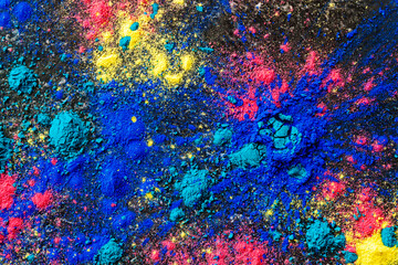 Top view abstract colorful Happy Holi background. Color vibrant powder on concrete. Colored splash explosion of dust texture. Flat lay holi dry paint decoration. Traditional indian hindi holiday.