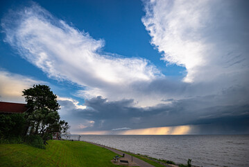 Anvils of thunderstorms over lake IJsselmeer, Netherlands at sunset