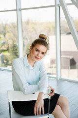 Portrait of a beautiful young businesswoman in the light modern office. Successful woman