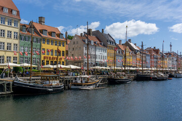 Fototapeta na wymiar view of the historic Nyhavn quarter in downtown Copenhagen with a tourist boat cruise barge in the foreground