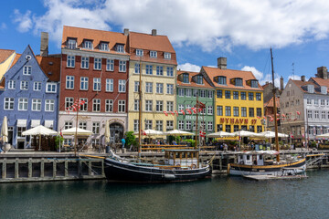 Fototapeta na wymiar view of the historic Nyhavn quarter in downtown Copenhagen with a tourist boat cruise barge in the foreground
