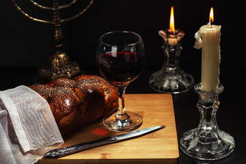 Shabbat Shalom. Challah bread, shabbat wine and candles on wooden table.