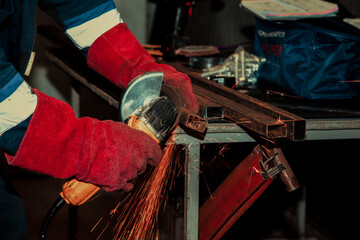Sparks flying over the working table during metal grinding.