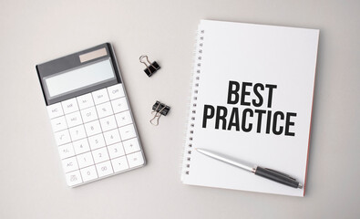The word best practice is written on a white background next to a pen ,calculator and reports. Business concept