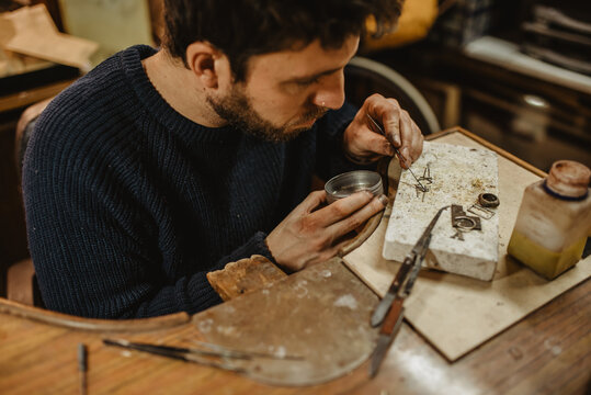 Adult jeweler working at workbench