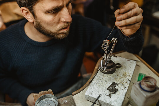 Goldsmith inspecting ring at workshop