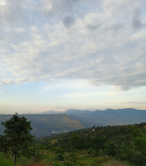Paisaje de montañas verdes y azules debajo de un cielo blanco 